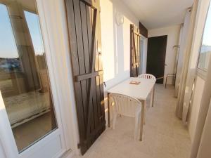 a small table and chairs in a room with a window at APPARTEMENT à 5 mn de la plage in Saint-Hilaire-de-Riez +12 photos