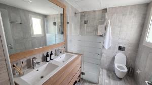 a bathroom with a sink and a toilet and a mirror at Gador Sea View in H̱adera