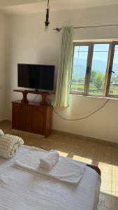 a bedroom with a flat screen tv and a bed at Hotel Engjell in Pogradec