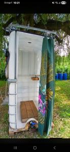 a small caravan with a surfboard and a tent at Chez Bernard in Mareuil-Caubert