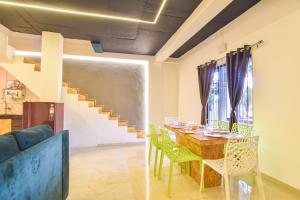 a dining room with a table and chairs and a staircase at II JAGUAR VILLA lI in Lonavala
