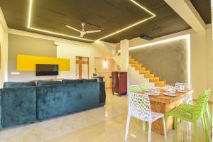 a living room with a couch and a table and chairs at II JAGUAR VILLA lI in Lonavala
