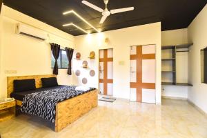a bedroom with a bed and a ceiling fan at II JAGUAR VILLA lI in Lonavala +22 photos