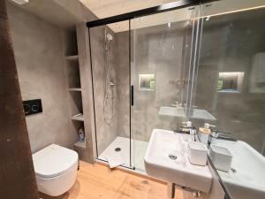 ein Badezimmer mit Dusche, Toilette und Waschbecken in der Unterkunft Eva's Seeblick in Krattigen + 67 Fotos