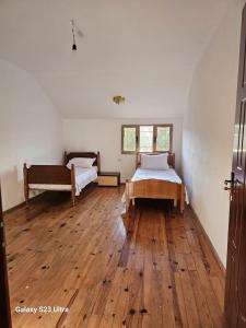 a bedroom with two beds and a wooden floor at Hotel Engjell in Pogradec