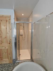 a shower with a glass enclosure in a bathroom at Maggies Cottage in Manorhamilton +21 photos