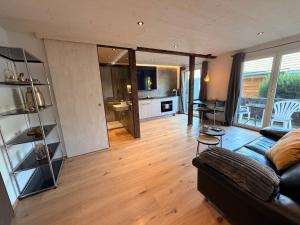 ein Wohnzimmer mit Sofa und eine Küche in der Unterkunft Eva's Seeblick in Krattigen