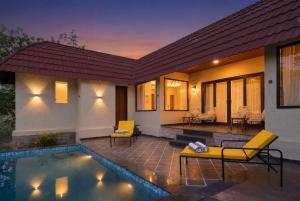 a villa with a swimming pool and a house at Aamba Bagh Resort Kumbhalgarh in Kumbhalgarh