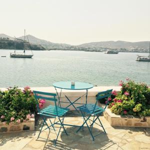 a table and chairs with a view of the water at Captain Bay's Unique Heritage Home in Finikas