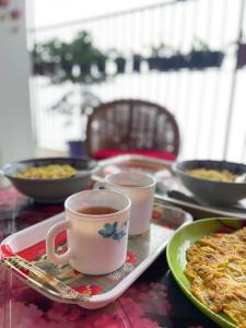 a table with a cup of coffee and a plate of food at Nini's Homestay, Kalimpong in Pedong +43 photos