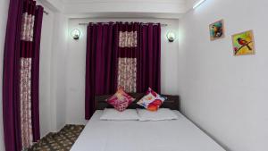 a bedroom with purple curtains and a bed with pillows at Nini's Homestay, Kalimpong in Pedong