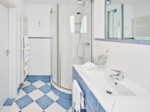 a white bathroom with a shower and a sink at Püttmanns Dorfhotel in Olpe