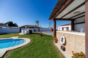 a backyard with a swimming pool and a house at VillaHaba BarrosaHome in Novo Sancti Petri