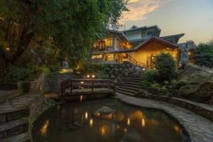 a house with a pond in front of it at Summit Norling Resort & Spa in Gangtok