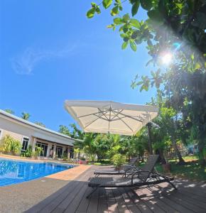 a group of chairs and an umbrella next to a pool at The Retreat in Panglao Island