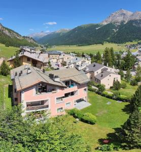 a group of houses in a valley with mountains at Splendida e soliva dimora con giardino in La Punt-Chamues-ch