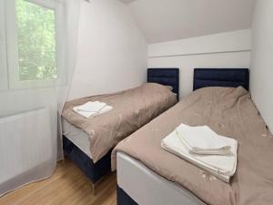 two twin beds in a room with a window at Vila Vidovic Drina in Bajina Bašta