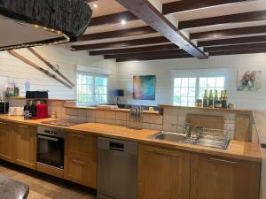 a large kitchen with wooden cabinets and a sink at Gîtes BEL'M in La Bresse