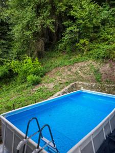 a blue swimming pool with two chairs in it at Vila Vidovic Drina in Bajina Bašta