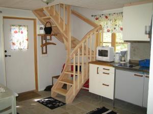 a kitchen with a wooden staircase in a tiny house at Fårö stonehouse in Fårö