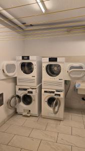 a laundry room with three washer and dryers at Splendida e soliva dimora con giardino in La Punt-Chamues-ch