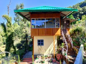 a tiny house with a large window and stairs at Himalaya View in Rānīkhet