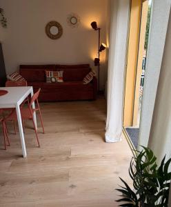 a living room with a couch and a table at Appartement La Parenthèse Verte - Capvern in Capvern