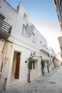 a white building with a door on a street at Palazzo '800 Cementine in Leverano