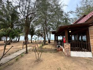 a building on the beach with trees and the ocean at Rumah Seruni@Zaki's Residence in Kampong Ru Lima +11 photos