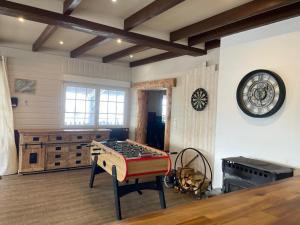 a room with a table and a clock on the wall at Gîtes BEL'M in La Bresse