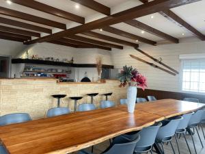 a large wooden table in a room with chairs at Gîtes BEL'M in La Bresse