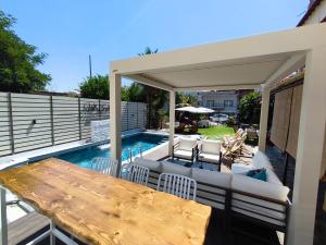 a patio with a table and chairs and a pool at Villa Evelin in Asprovalta