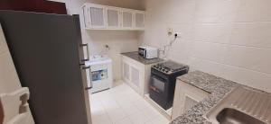a small kitchen with a stove and a sink at Star Suites in Salalah