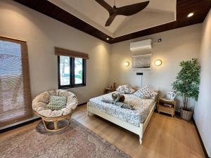 a living room with a bed and a chair at Rumah Seruni@Zaki's Residence in Kampong Ru Lima