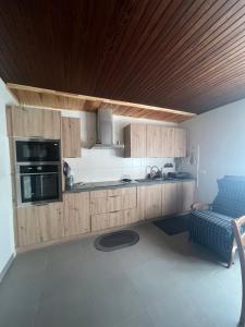 a kitchen with wooden cabinets and a blue couch at Logement avec parking max 7 personnes in Eauze +7 photos