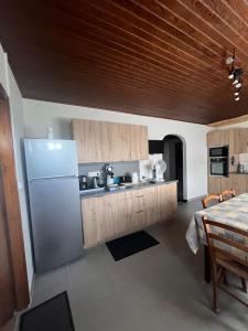 a kitchen with a refrigerator and a table at Logement avec parking max 7 personnes in Eauze