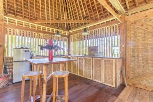 a kitchen with a table and stools in a cabin at Cosy Cottage Living Harmoniously in Tabanan