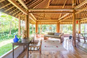 a large wooden pavilion with a couch and a table at Cosy Cottage Living Harmoniously in Tabanan +40 photos
