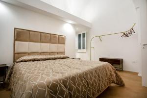 a bedroom with a large bed in a white room at Palazzo '800 Cementine in Leverano