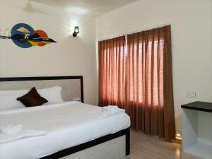 a bedroom with a large bed and a window at Tutti Cafe in Hampi +22 photos