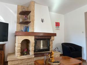 a living room with a stone fireplace with a tv at Maison individuelle a Arreau in Arreau