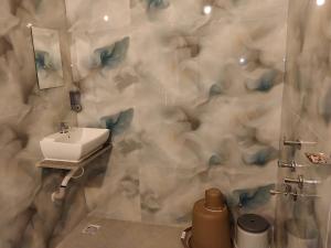 a bathroom with a sink and a mirror and a shower at Tutti Cafe in Hampi