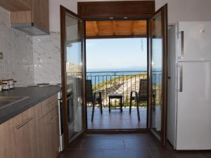 a kitchen with a sliding glass door to a balcony at Archontiko Nikolaou Keramidi in Keramídhion