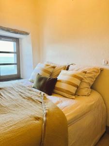 ein Bett mit mehreren Kissen darauf in einem Zimmer in der Unterkunft Cap Hélios, vue mer à couper le souffle à Centuri in Morsiglia