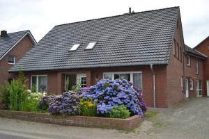 a house with a bunch of flowers in front of it at Wohnen nahe der Ems in Fresenburg