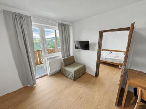 a room with a mirror and a chair and a bed at Wellness Apartmány Pastviny in Pastviny