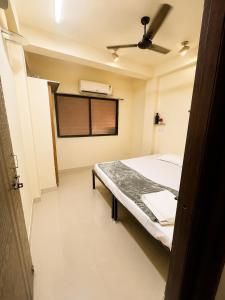 a small room with a bed and a window at Elora Hotel in Ujjain