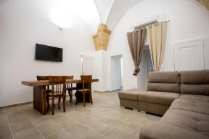 a living room with a table and a couch at Palazzo '800 Cementine in Leverano