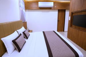 a bedroom with a bed with a flat screen tv at Raahi Home Stay Near Iskcon temple & Pushpa Mission Hospital in Ujjain +25 photos
