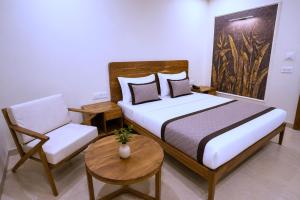 a bedroom with a bed and a chair and a table at Raahi Home Stay Near Iskcon temple & Pushpa Mission Hospital in Ujjain
